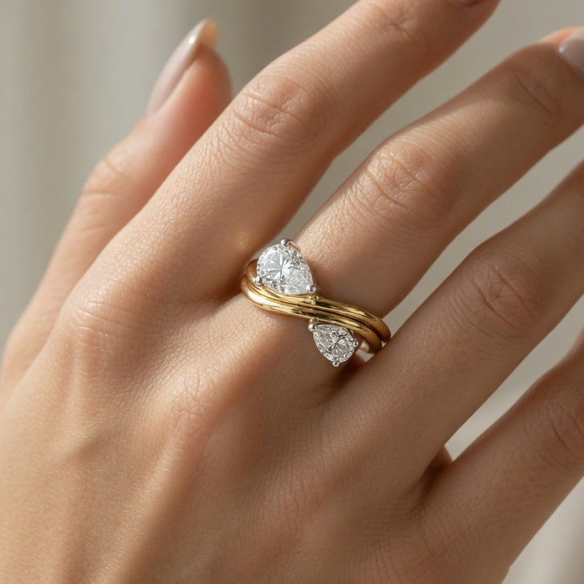 Lifestyle photograph of a model wearing the EKATVĀ Infinity Birthstone Ring, illustrating how the elegant infinity design sits naturally on the finger. The image demonstrates the ring's minimalist luxury aesthetic, comfortable everyday wear and sophisticated styling while highlighting its personalized dual birthstone concept. 925 sterling silver, moissanite, 1 micron 18k gold plating